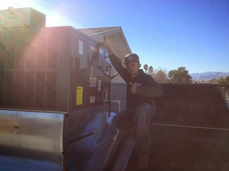HVAC technician performing AC Tune-Up on a rooftop unit in Comstock